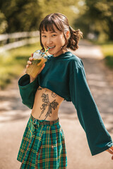 Pretty smiling girl in in a summer park with a glass of lemonade in hand