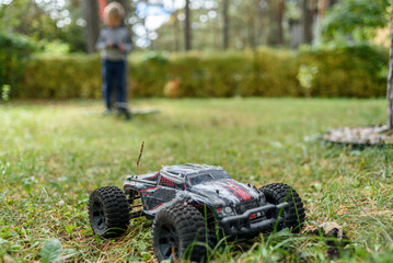 Boy playing with remote control monster truck car outside in courtyard © molenira