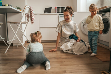Parent playing with kids and laundry items for machine washing