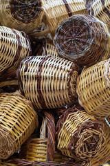 Closeup on group of handmade wicker rustic baskets container for shopping. Natural colors and texture. Eco concept. Wooden hanging wicker pots. Traditional greek street shop. Vertical. Soft focus