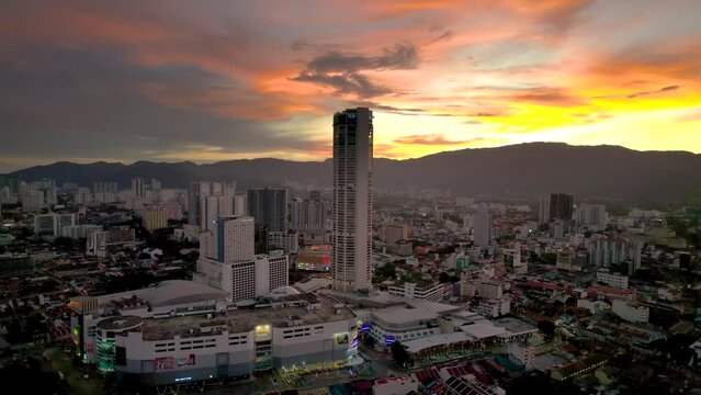 Aerial, skyline of George Town, Penang Island in Malaysia during sunset with "The Top" in the center, 4K