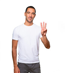 Young man making a number three gesture