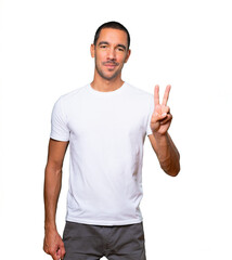 Young man making a number two gesture