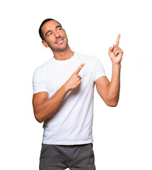 Amazed young man pointing up with his finger