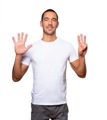 Happy young man doing a number eight gesture with his hands