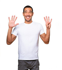 Naklejka premium Happy young man doing a number nine gesture with his hands