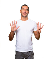 Fototapeta premium Happy young man doing a number nine gesture with his hands