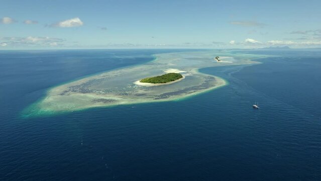Coral Reef and Island in Raja Ampat Indonesia, (Koon Island). Aerial Drone shot orbiting tropical island in 4K.