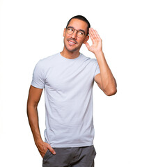 Fototapeta premium Happy young man smiling and making a gesture of trying to hear something