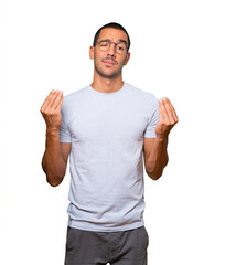 Fototapeta premium Confused young man making an italian gesture of not understand