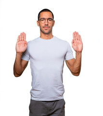 Fototapeta premium Serious young man making a gesture of stop with his palm