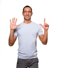 Naklejka premium Happy young man doing a number seven gesture with his hands