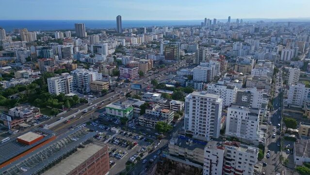 Aerial view of traffic in city of Santo Domingo with skyscraper buildings and Caribbean Sea 