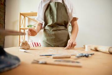 Young female pottery master with supplies recording vlog at home studio. Hobbies and leisure activities. Clay modeling process, learning the basics of pottery