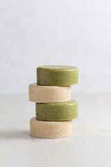 Eco friendly solid handmade colorful shampoo bars on light colored background close-up.
