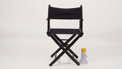 Back of Black director chair and megaphone on white background.