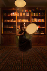 Girl in library room with a shaman's tambourine