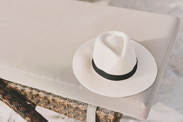 Fedora hat on sunbed at the beach. Vacation and relax concept. Sun protection accessory - 537493880