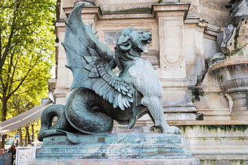 The Fontaine Saint-Michel located in Place Saint-Michel in the 6th arrondissement in Paris, France. Dragon by Henri Alfred Jacquemart in front of Fontaine - obrazy, fototapety, plakaty