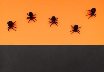 Some black spider toys. Orange and black background