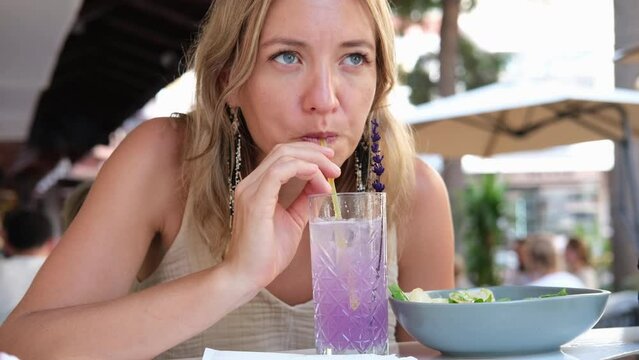 Woman drinking a cold non-alcoholic cocktail in a cafe.