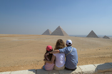 Dreikopfige Familie schaut sich die Pyramiden von Gizeh an. Ansicht von hinten Mädchen, Mutter und...