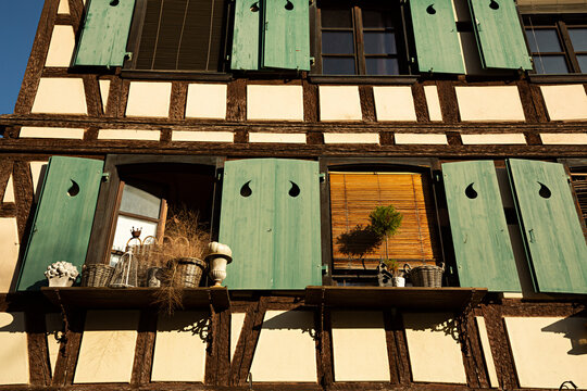 Casa con entramado de madera y contraventanas de madera verde.