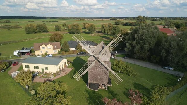 Low sun makes long shadows. Perfect aerial view flight fly reverse drone
of a Trestle windmill in brandenburg Germany at summer golden hour 2022. 4k marnitz Cinematic