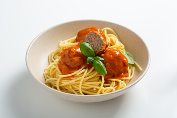 Close up of spaghetti pasta with meatball with red sauce in white bowl