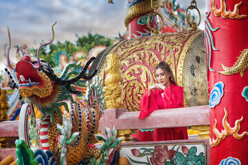 chinese dragon statue. chinese dragon statue in temple. portrait of a woman. person in traditional costume. woman in traditional costume. Beautiful young woman in a bright red dress.