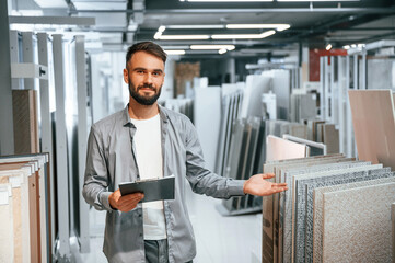 Manager with notepad. Stylish beautiul man is in the store of goods for the home