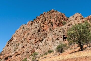 Fototapeta premium Red structural rock against the blue sky in the mountains of Armenia.