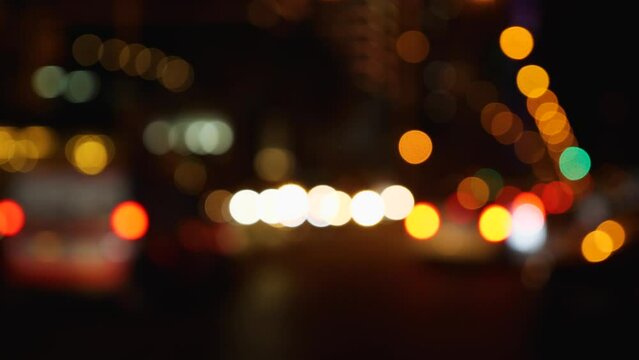 Defocused lights of the city at night. Abstraction. Blurry cars driving through the city. Lights from headlights, streetlights and clearance lights. Blurred background. Slow motion