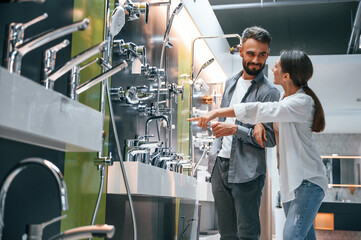 Fun couple looking for products. Woman and man is in the store of goods for the home