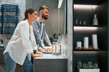 Indoors together. Woman and man is in the store of goods for the home
