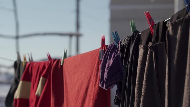 Washed clothes are dried outdoors in winter. Frosty, sunny day in the countryside.