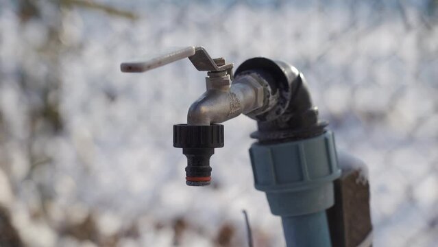 TERNOPIL, UKRAINE - DECEMBER 15, 2021: A woman's hand opens a tap without water. Drought in the countryside. Winter period.
