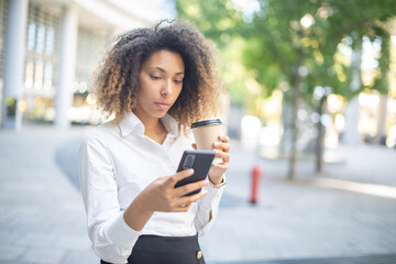 Black business woman using her mobile phone in a business environment