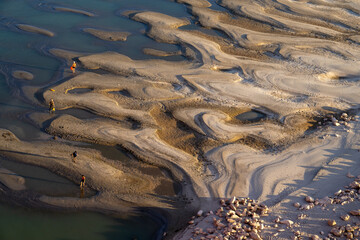 people playing on the mud beach in sunset