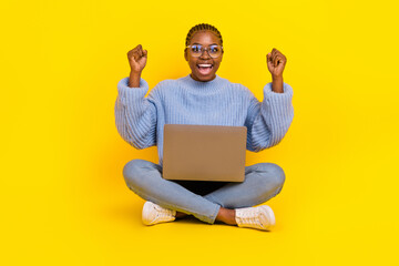 Full legth portrait of young pretty girl blogger got million subscribers finally celebrate holding laptop isolated on yellow color background