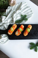 Eclairs with salmon, fresh vegetables and herbs, gourmet snacks.