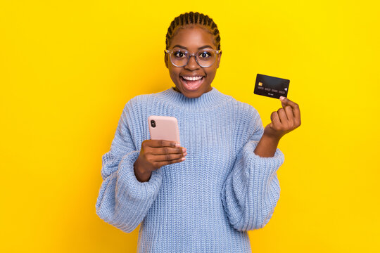 Photo Of Young Girl Blogger Dressed Knitwear Advertises New Credit Banking Card Good Terms Use Isolated On Yellow Color Background