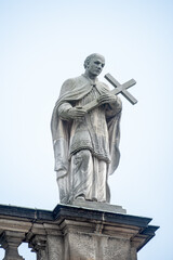 Old roof statute of priest or monk holding a big cross at Dome base of the Cathedral of Holy Trinity, historical center of Dresden, Germany.