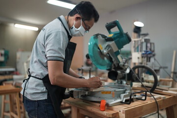 Contemporary Carpenter Working, Portrait of modern carpenter making wood furniture while working in joinery lit by sunlight with factory background on small business concept, copy space