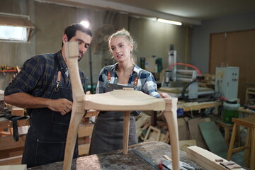 Contemporary Carpenter Working, Portrait of modern carpenter making wood furniture while working in joinery lit by sunlight with factory background on small business concept, copy space