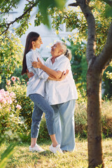 Fototapeta premium Conception of love to a parent. Young woman is with her senior mother is in the garden