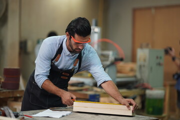 Contemporary Carpenter Working, Portrait of modern carpenter making wood furniture while working in joinery lit by sunlight with factory background on small business concept, copy space