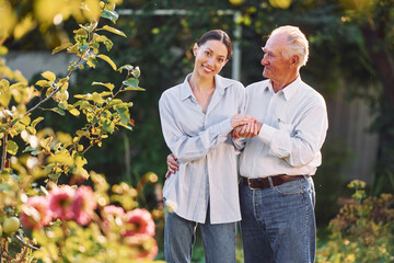 Conception of love. Embracing each other. Daughter is with her senior father in the garden at daytime