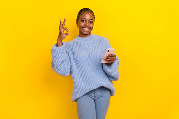 Photo of young cornrows hairdo girl dressed blue jumper showing okey sign meaning everything good isolated on yellow color background