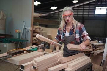 Contemporary Carpenter Working, Portrait of modern carpenter making wood furniture while working in joinery lit by sunlight with factory background on small business concept, copy space